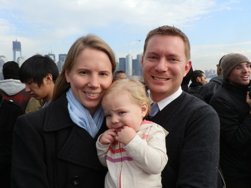 Susan, Fiona, and Dustin on the Statue of Liberty/Ellis Island ferry with Lower Manhattan in the background, 31 December 2011.