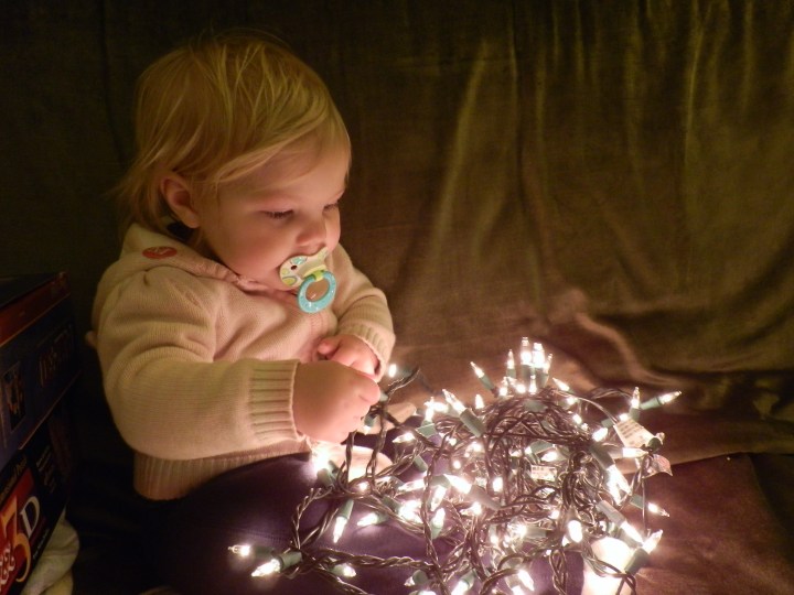 Fiona plays with a string of lights as we take down our tree on 7 January 2011.