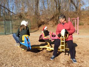 Charlotte, Fiona, and Grammy ride a merry-go-round.